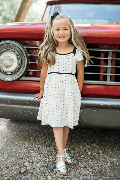Ivory polka dot little girl dress with black trim and black dots