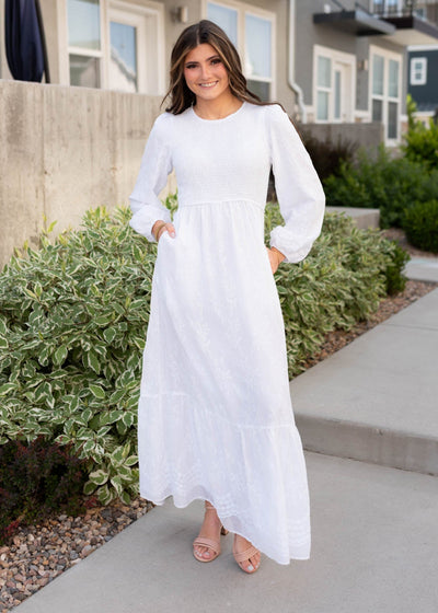 White smocked dress with long sleeves and pockets