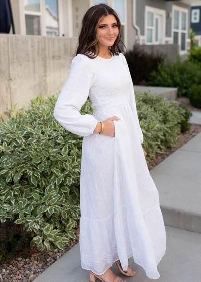 Side view of the white smocked dress with pockets