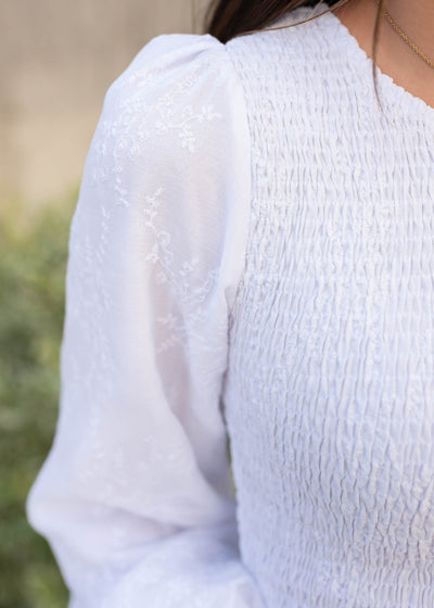 Close up of the embroidered fabric on the white smocked dress