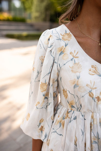 Close up of the sleeve and fabric of the cream flower dress