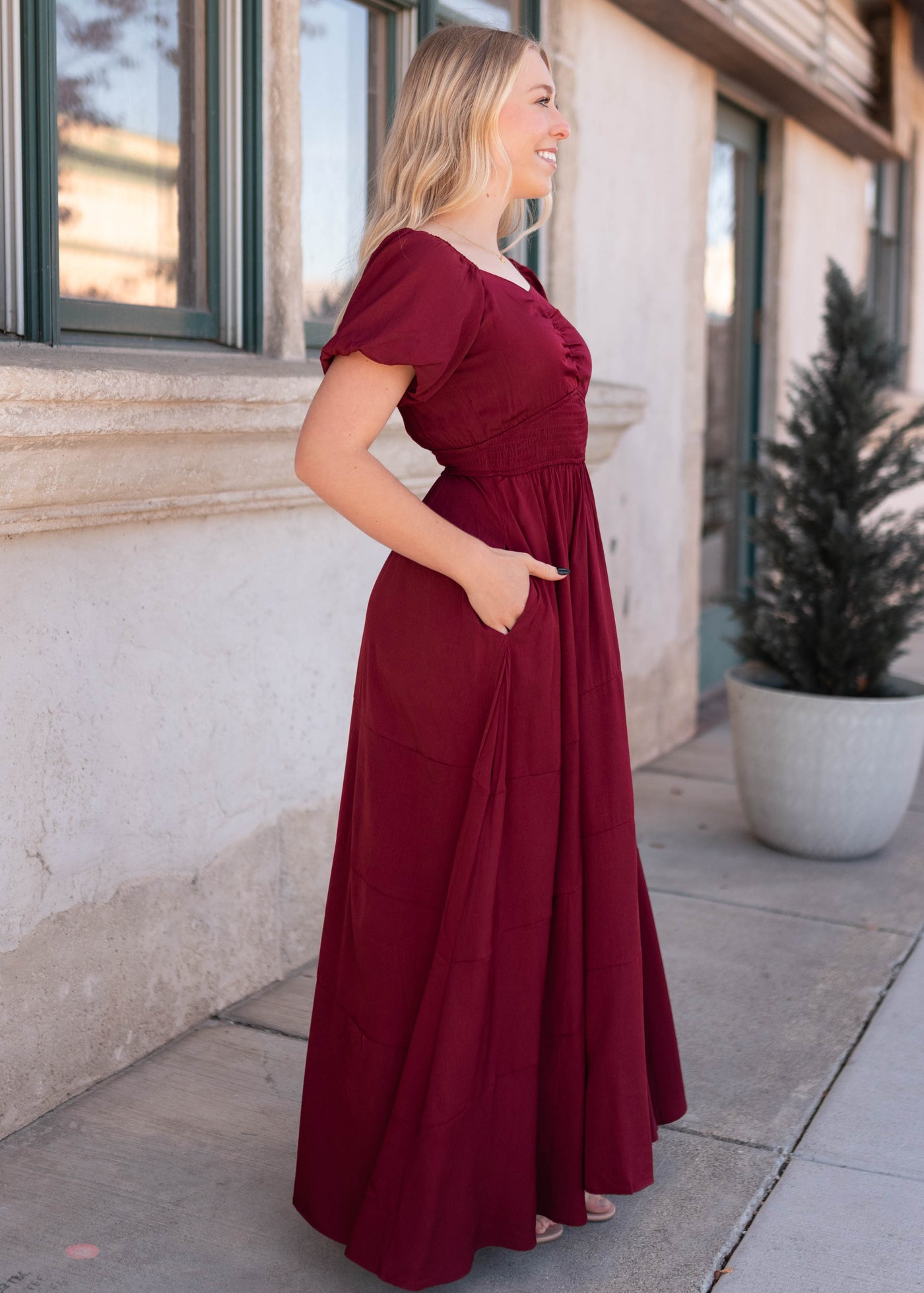 Side view of the burgundy smocked dress with pockets