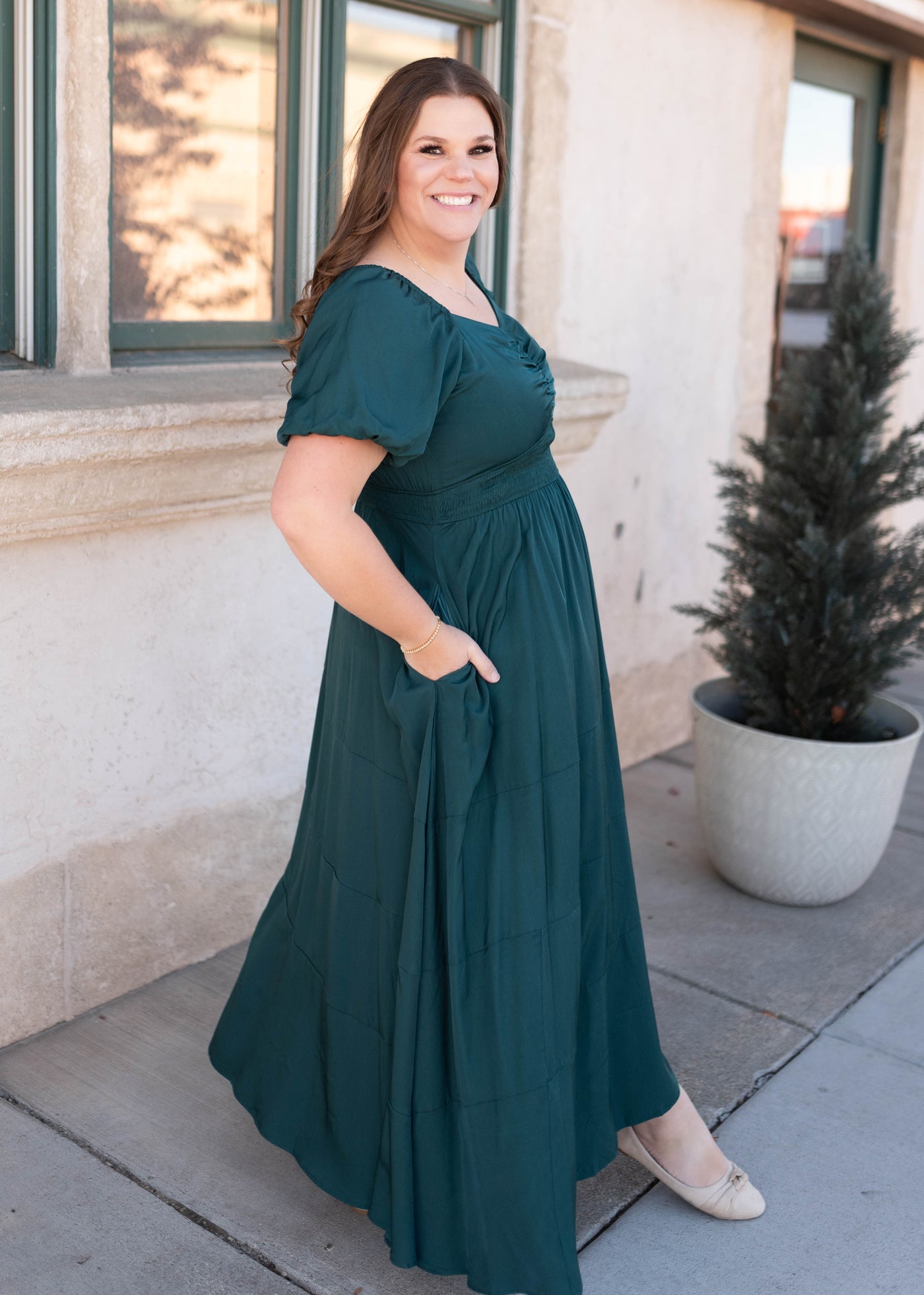 Side view of the plus size green smocked dress with pockets and short sleeve 