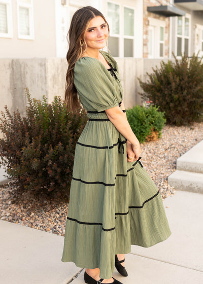 Side view of the olive tiered dress with black trim at Lena Layne