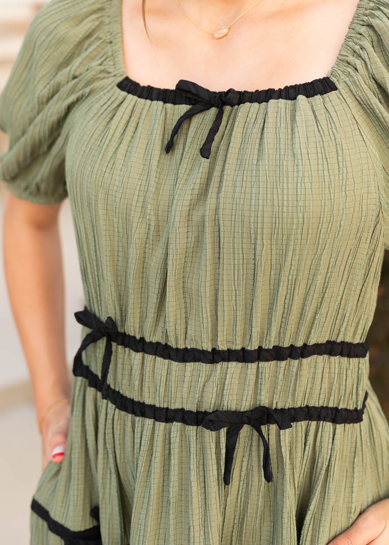 Close up of the square neckline on the olive tiered dress at Lena Layne