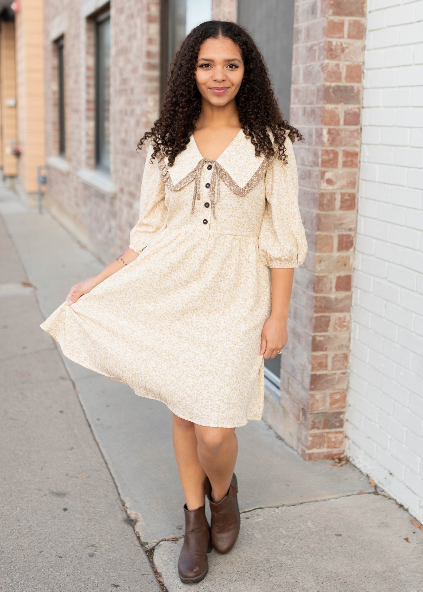 Tan ruffle and bow on the collar onthe taupe floral dress
