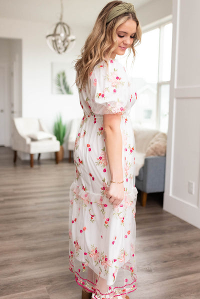 Side view of a white embroidered floral dress