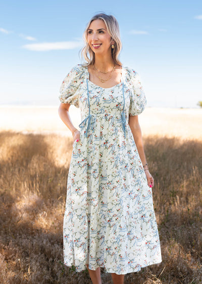 White ribbon pattern dress with blue trim and bows at the waist line