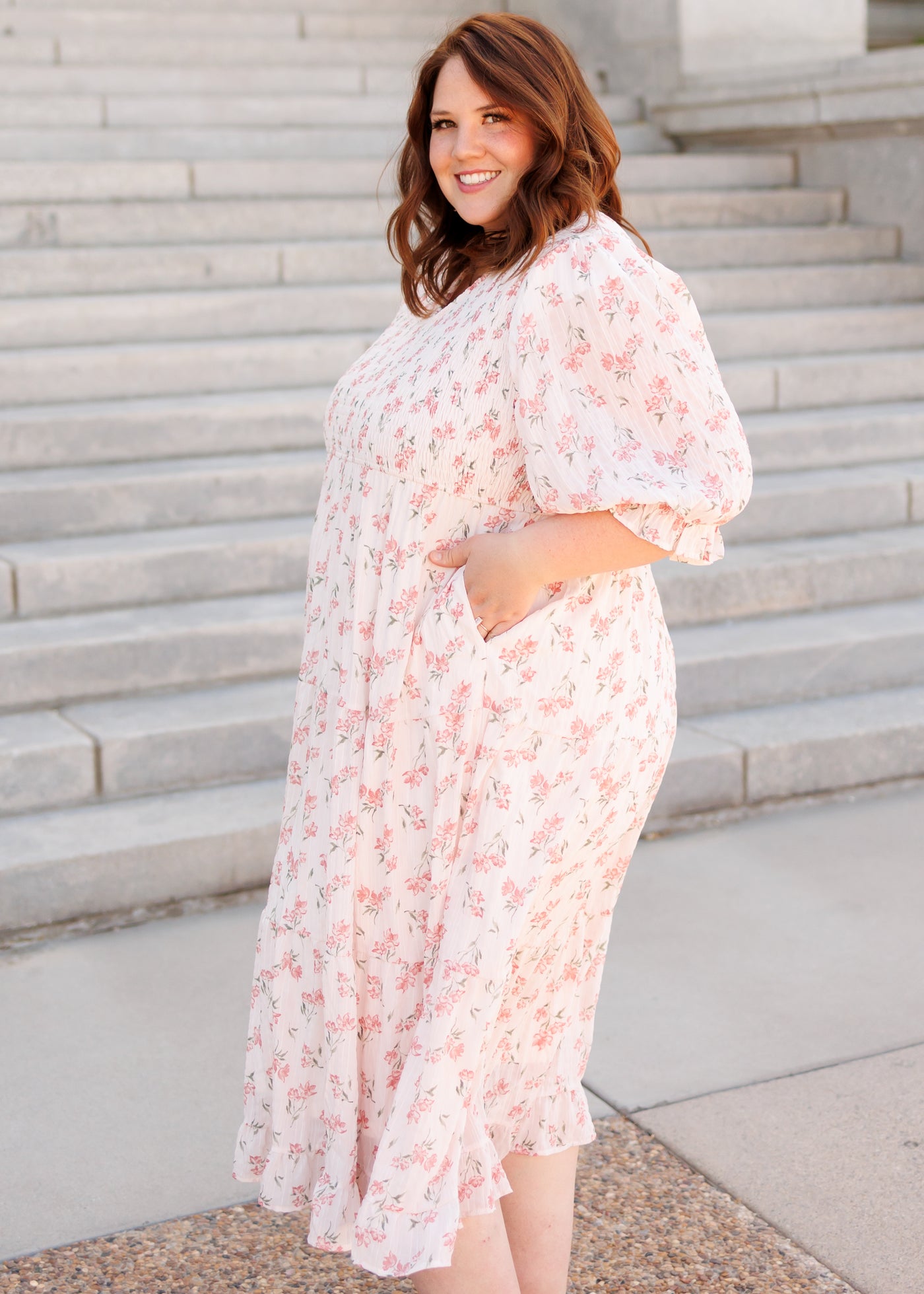 Side view of the plus size pink floral tiered dress with pockets 