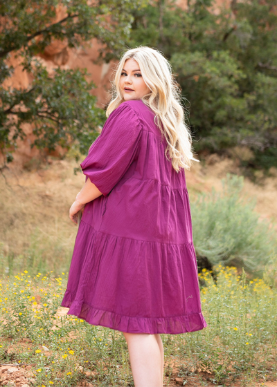 Side view of a plus size berry dress with pockets