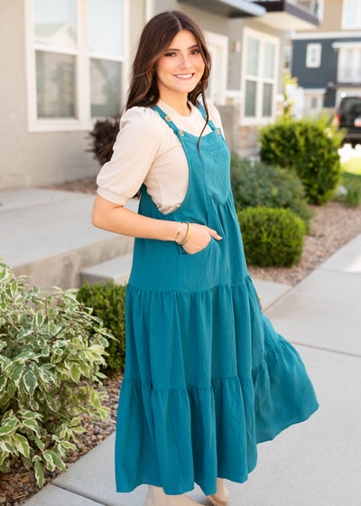 Side view of the tiered teal overall dress with pockets