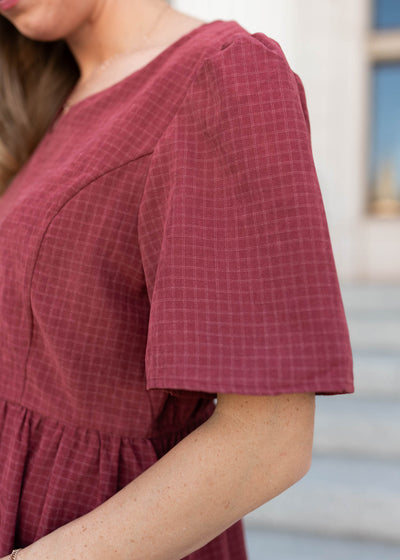 Close up of the sleeve and fabric in the dusty maroon dress