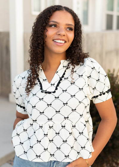 Black ribbon top with black trim on the sleeves and neckline
