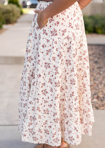 Side view of the tan floral skirt with pockets and red flowers