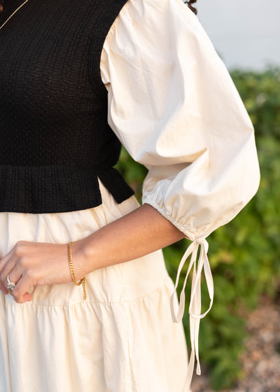 Close up of the sleeve and ties on the black sweater vest dress