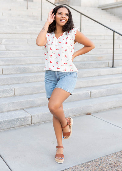 White cherry top with ruffle at the shoulder