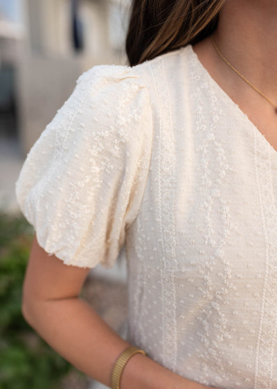 Close up of the fabric and the sleeve on the cream embroidered dress