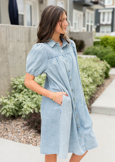 Side view of the denim button down dress with pockets