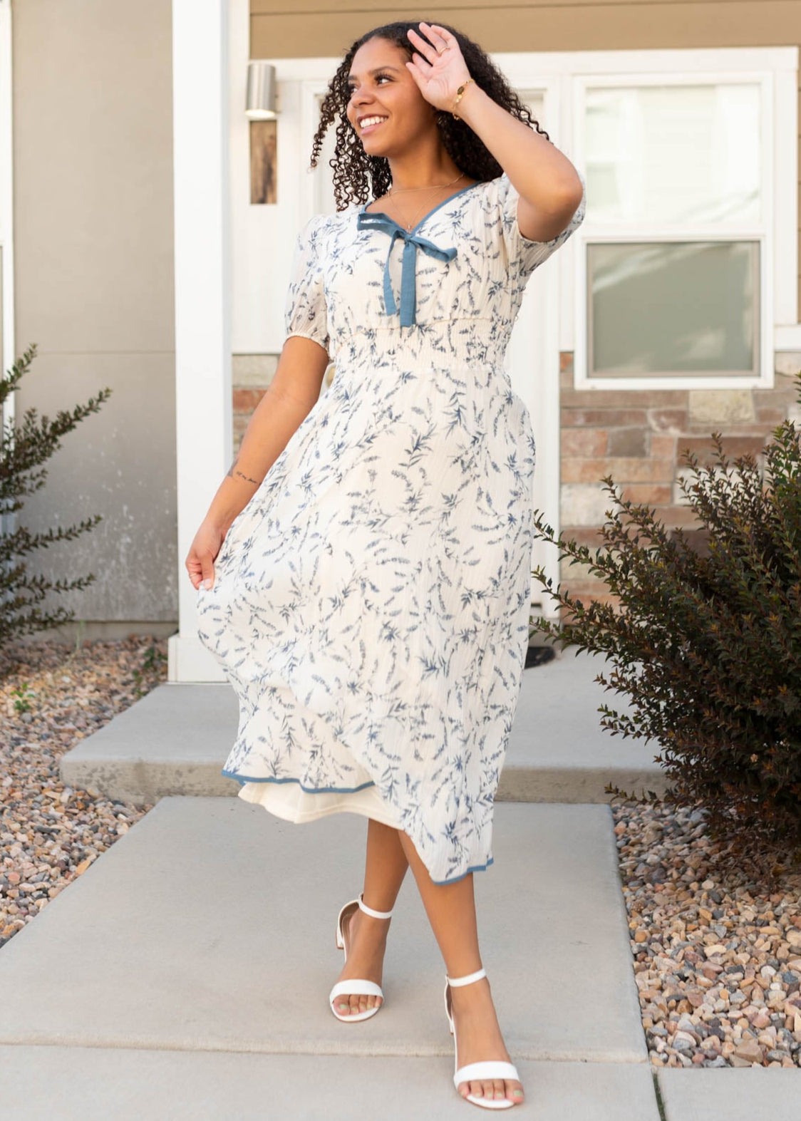 Modest cream floral dress with short sleeves with a blue bow at the neck