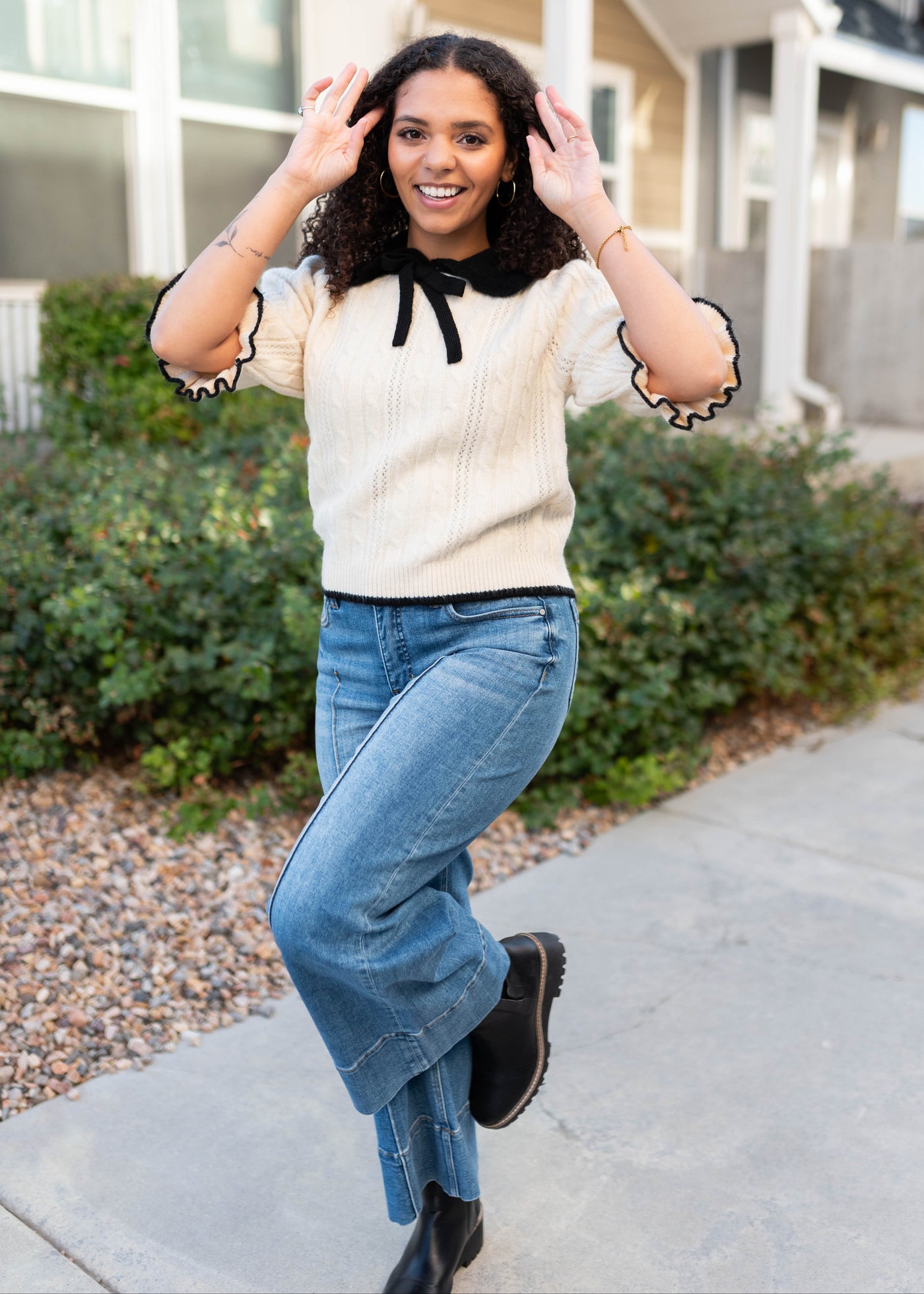 Black bow, collar and trim on the cream collar top with short sleeves