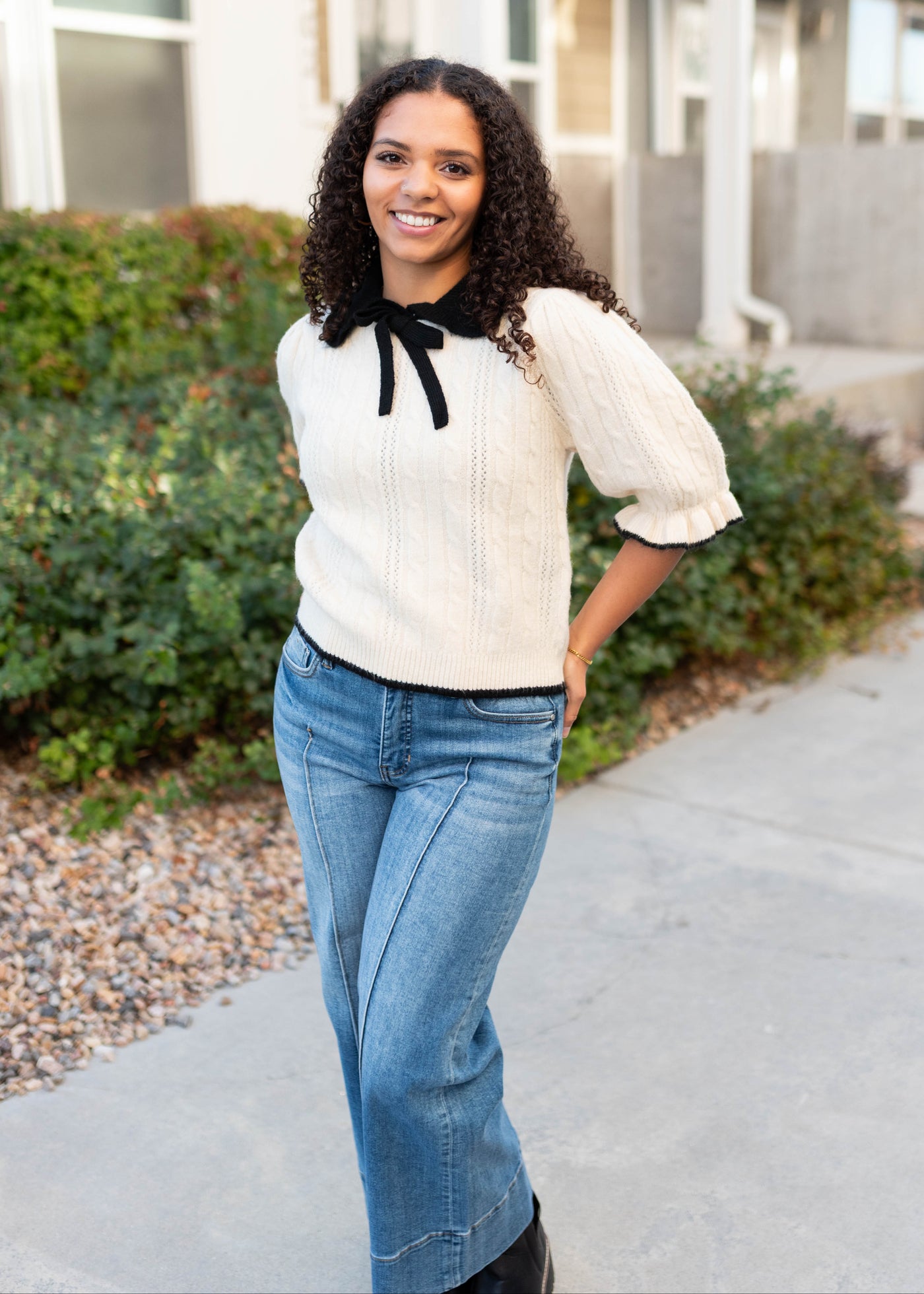 Black collar and bow on the cream collar top