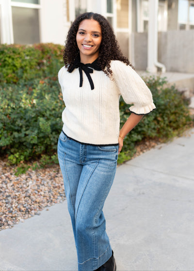 Black collar and bow on the cream collar top
