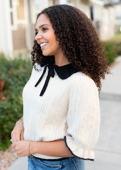 Side view of the cream collar top with black collar