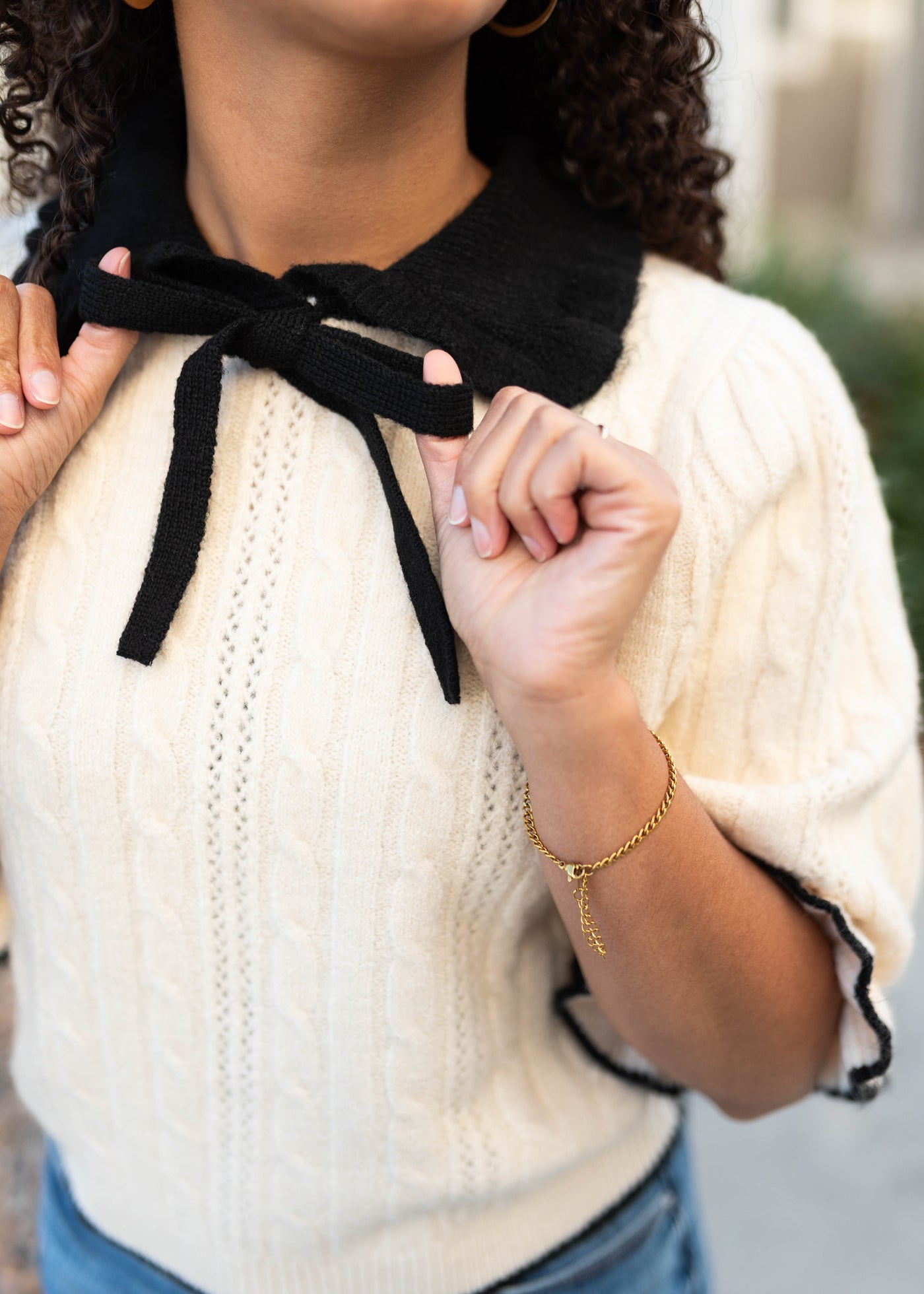 Close up of the cream collar top with blag bow
