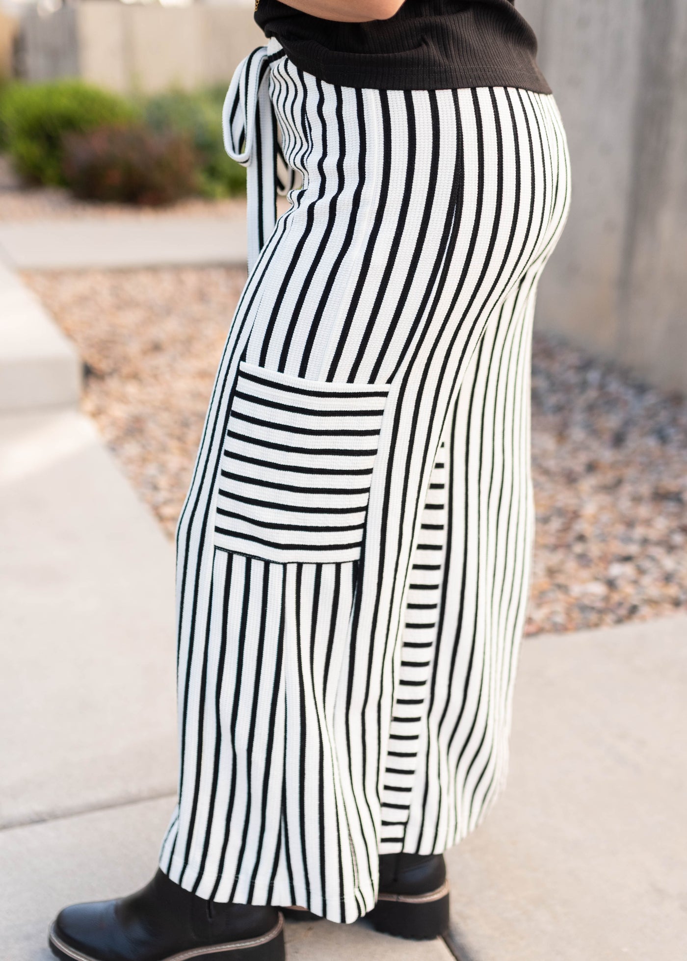 Side view of the black stripe pants with side pockets