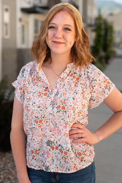 Ivory floral top with buttons at the neck and short sleeves