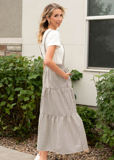 Side view of the charcoal stripe overall dress with pockets and a tiered skirt sold at Lena Layne