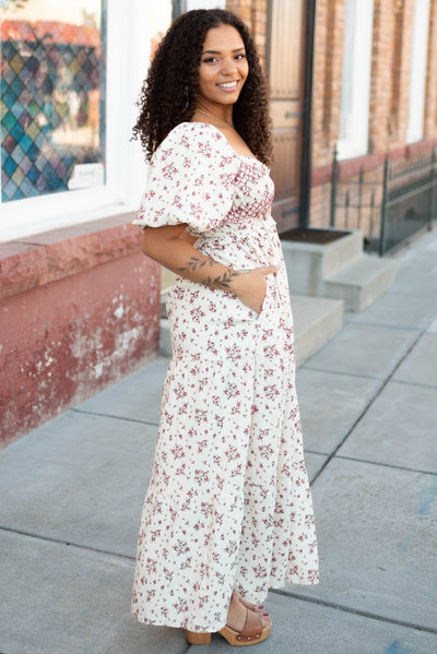Side view of the modest beige floral smocked dress with pockets