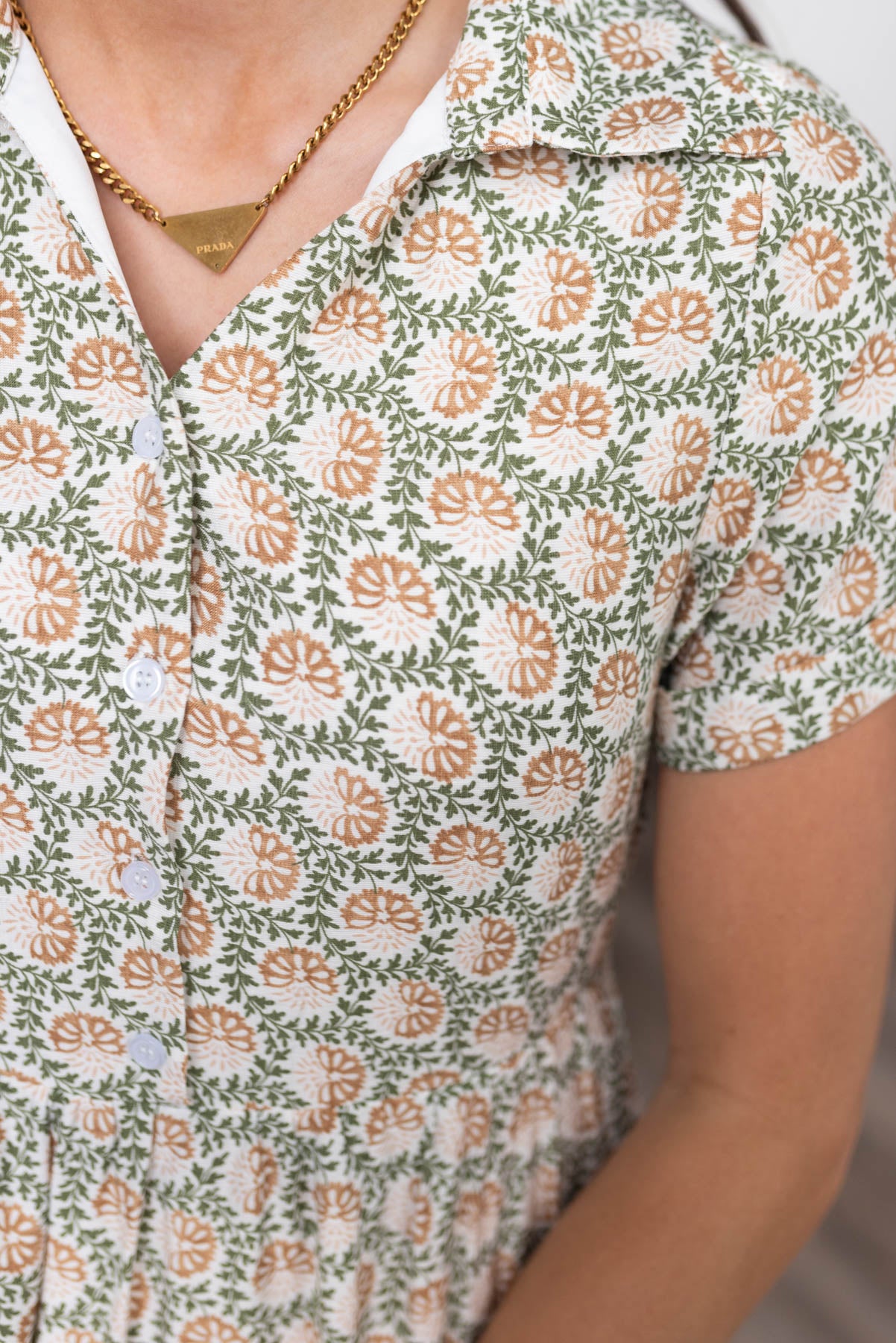 Close up of the buttons and fabric on the green floral collared dress