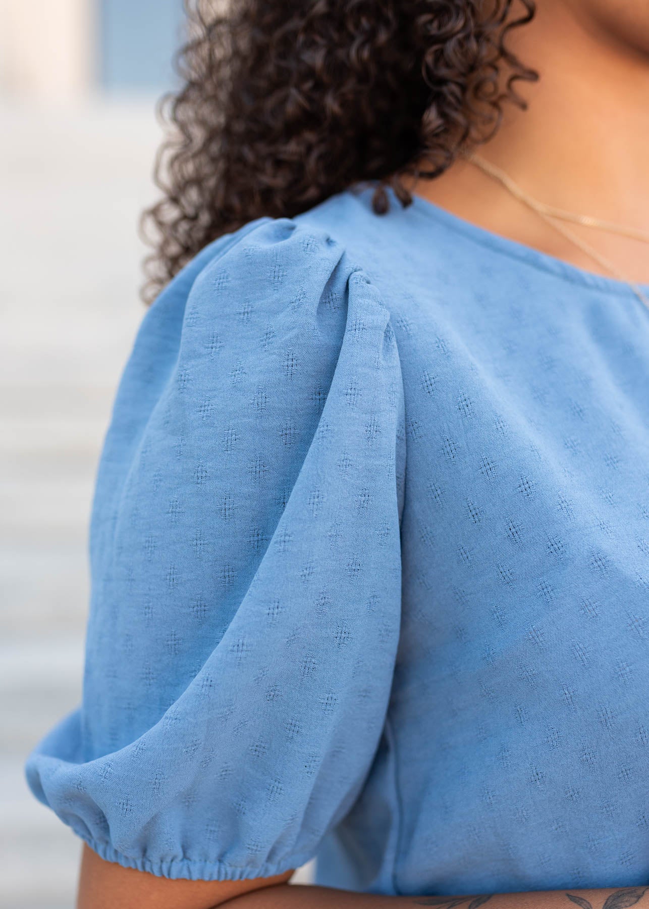 Close up of the sleeve and fabric on the blue peplum shirt