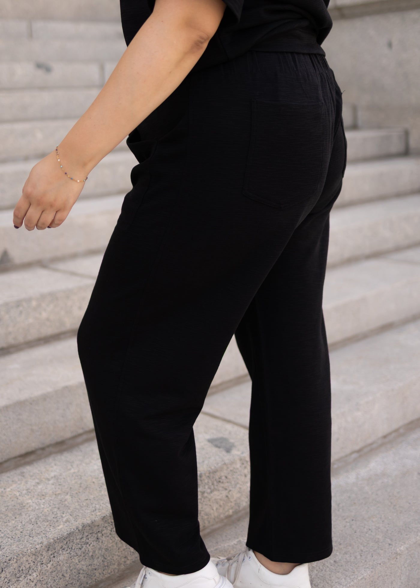 Side view of the plus size black knit pants