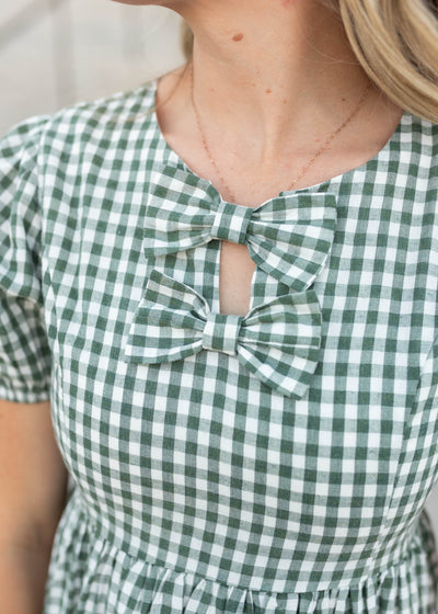 Close up of the bows and the fabric on the sage gingham ow dress