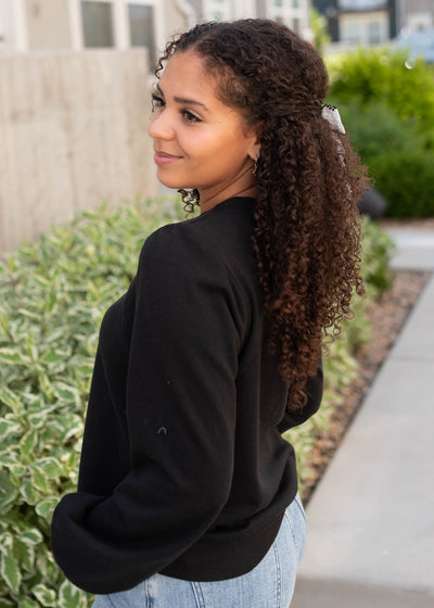Side view of the black long sleeve top