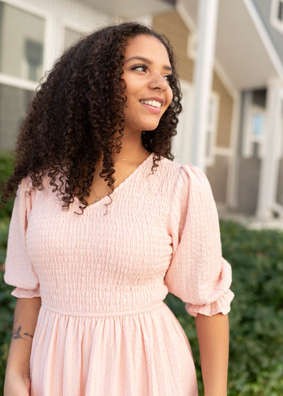 Close up of the smockeing on the modest blush smocked dress