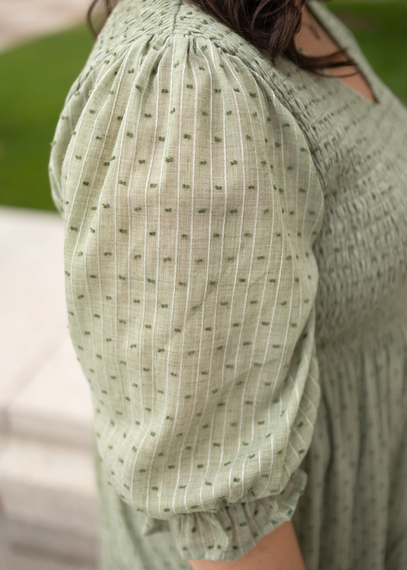 Close up of the sleeve on the plus size green smocked dress