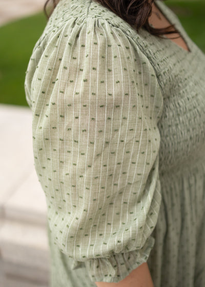 Close up of the sleeve on the plus size green smocked dress