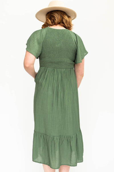 Back view of a buttercream satin dress with a V-neck and smocked bodice.