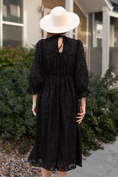 Back view of a black floral dress that ties in the back
