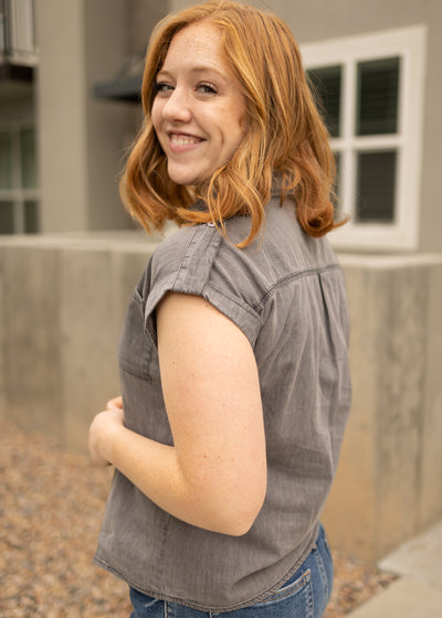 Side view of a light grey denim top