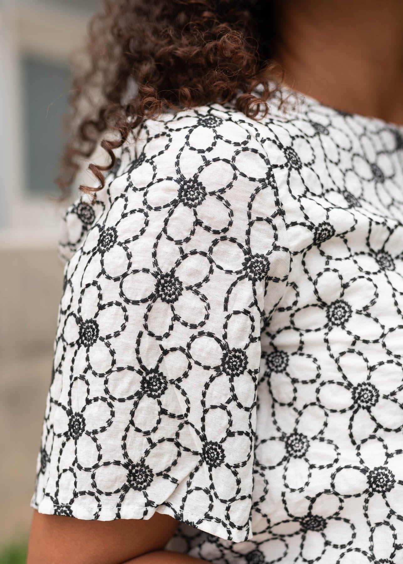 Close up of the sleeve and fabric on the black floral embroidered shirt