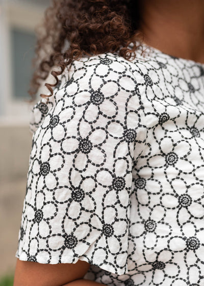 Close up of the sleeve and fabric on the black floral embroidered shirt