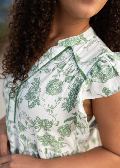 Close up of the fabric and sleeve on the green floral pattern dress