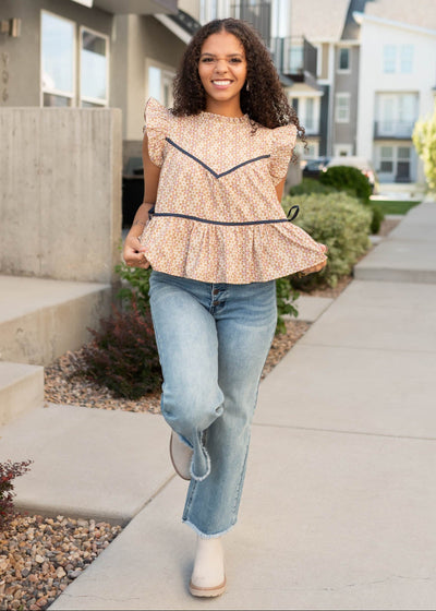 Babydoll style taupe floral top with gathering at the waist and navy trim