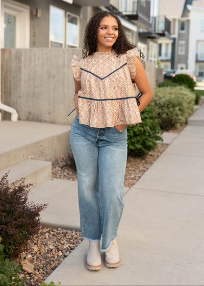 Ruffl at the neck and sleeve on the sleevless taupe floral top at Lena Layne