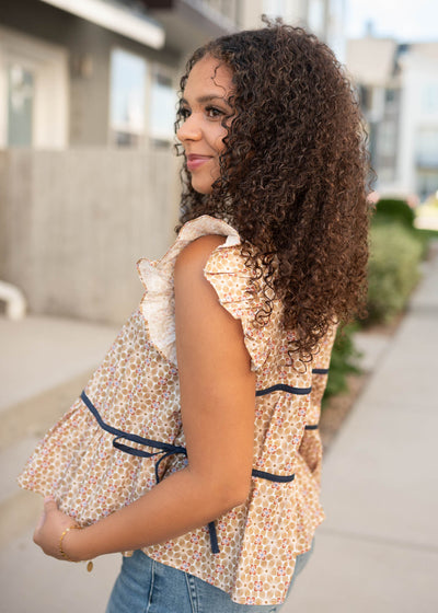Side view of the taupe floral top with ruffle on the sleeve