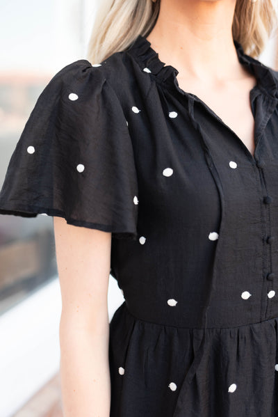 Close up of the fabric and sleeve on the black polka dot dress